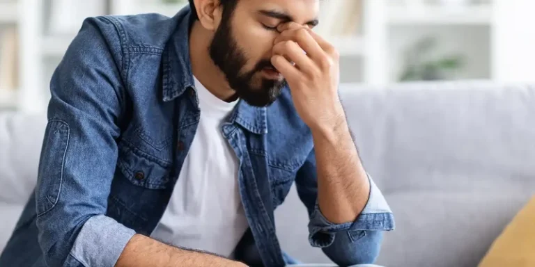 kembali mental health man sitting couch hand face