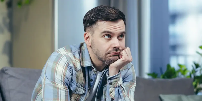 kembali mental health man sitting couch looking camera