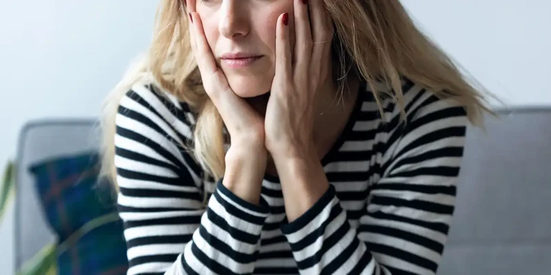 kembali mental health woman sitting couch hands face