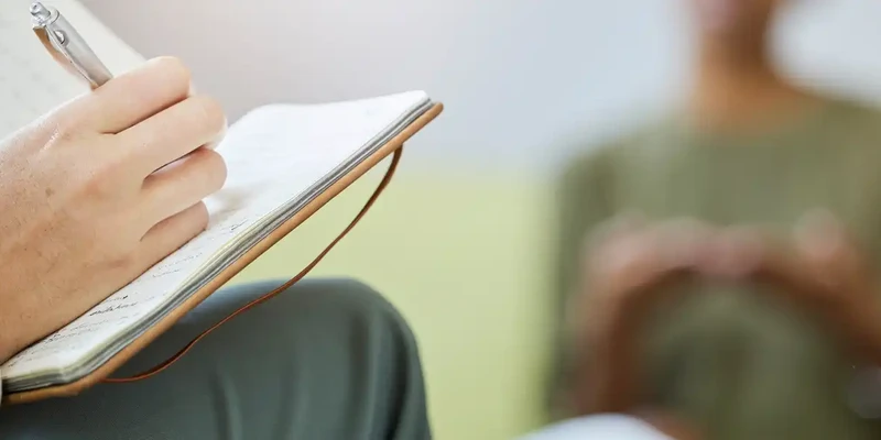 kembali therapy person holding pen writing book