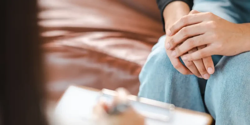 kembali therapy woman sitting couch holding hand