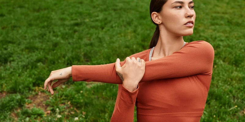 kembali yoga woman orange sweater standing field